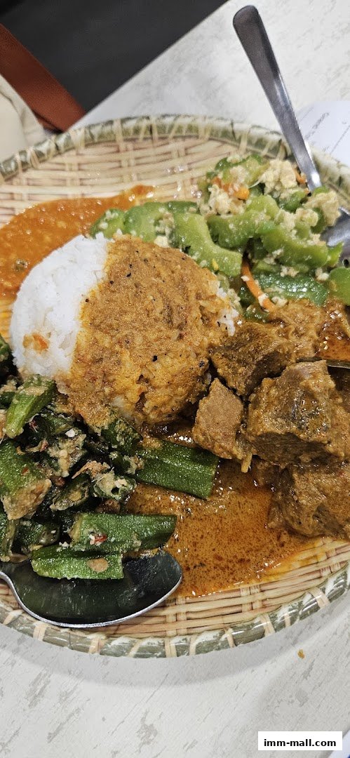 A close-up of a delicious meal featuring rice, curry, okra, and bitter gourd.