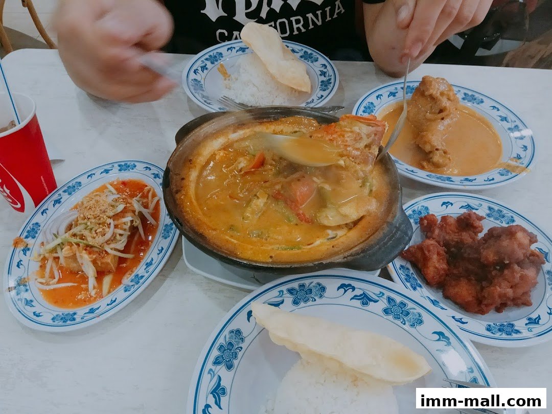 A table laden with various dishes, including curry, fried chicken, and a salad, suggesting a meal at Red Ginger.