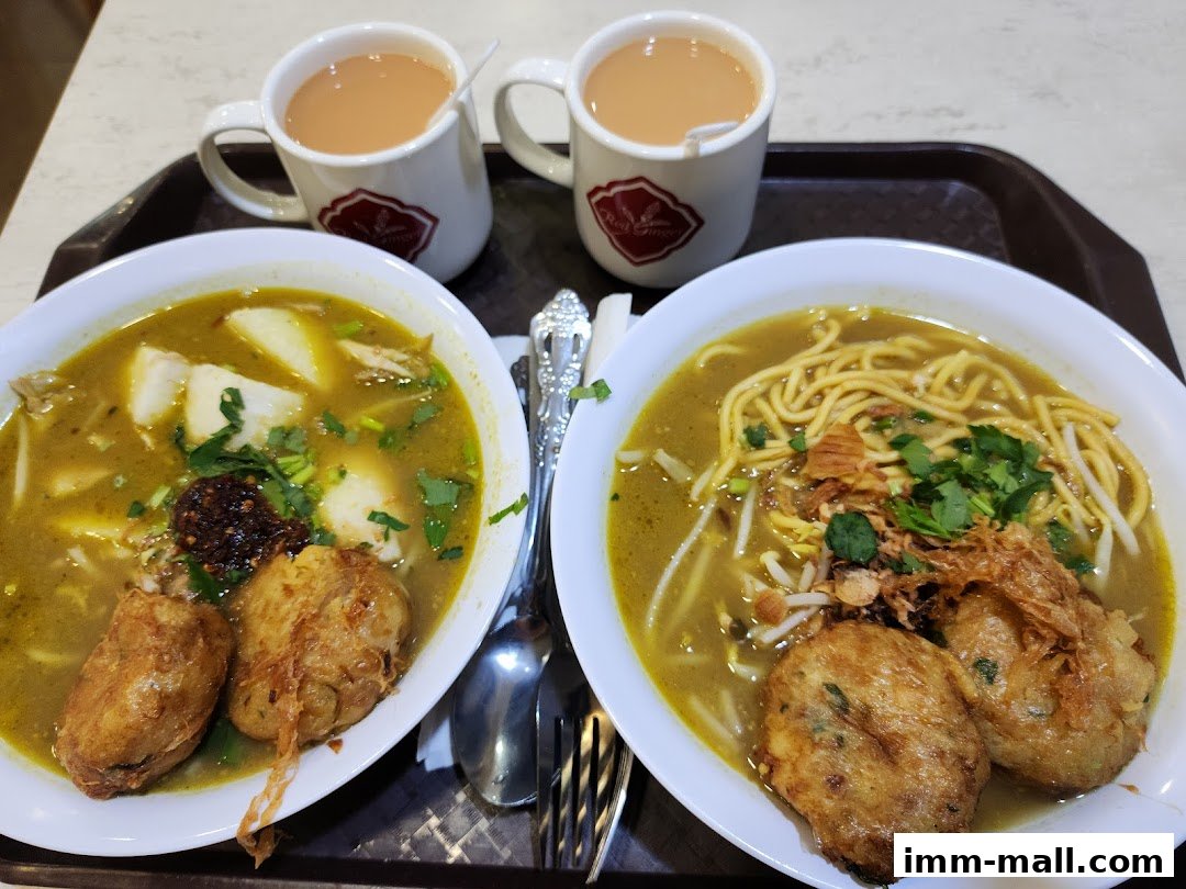 Two bowls of noodle soup and two cups of tea on a tray.
