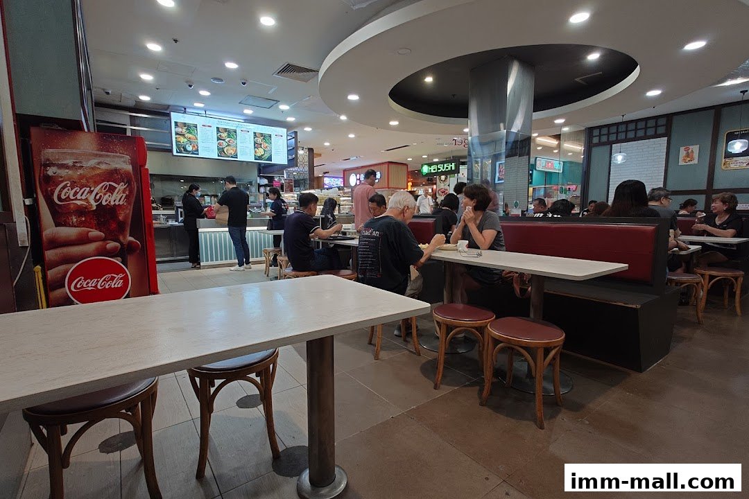 Diners are seated at tables inside a busy Red Ginger restaurant with a Coca-Cola advertisement.