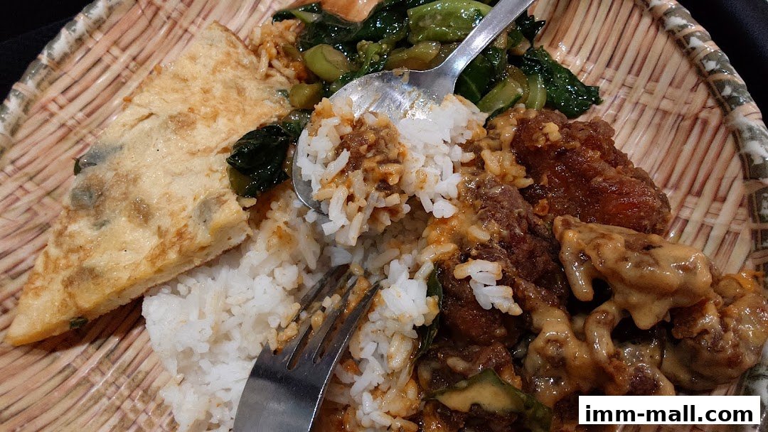 A close-up of a delicious meal with rice, fried chicken, vegetables, and omelet.