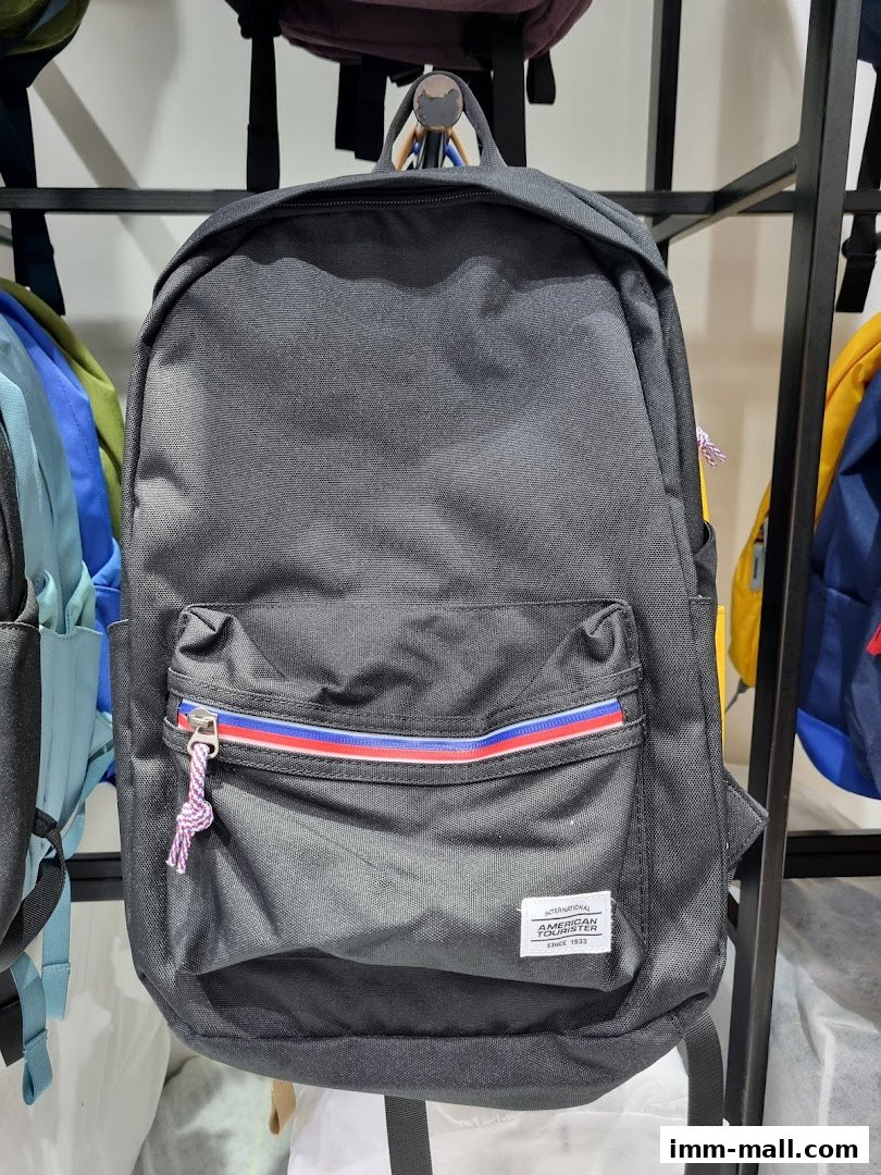 A black American Tourister backpack with a red and blue stripe detail on the front pocket.