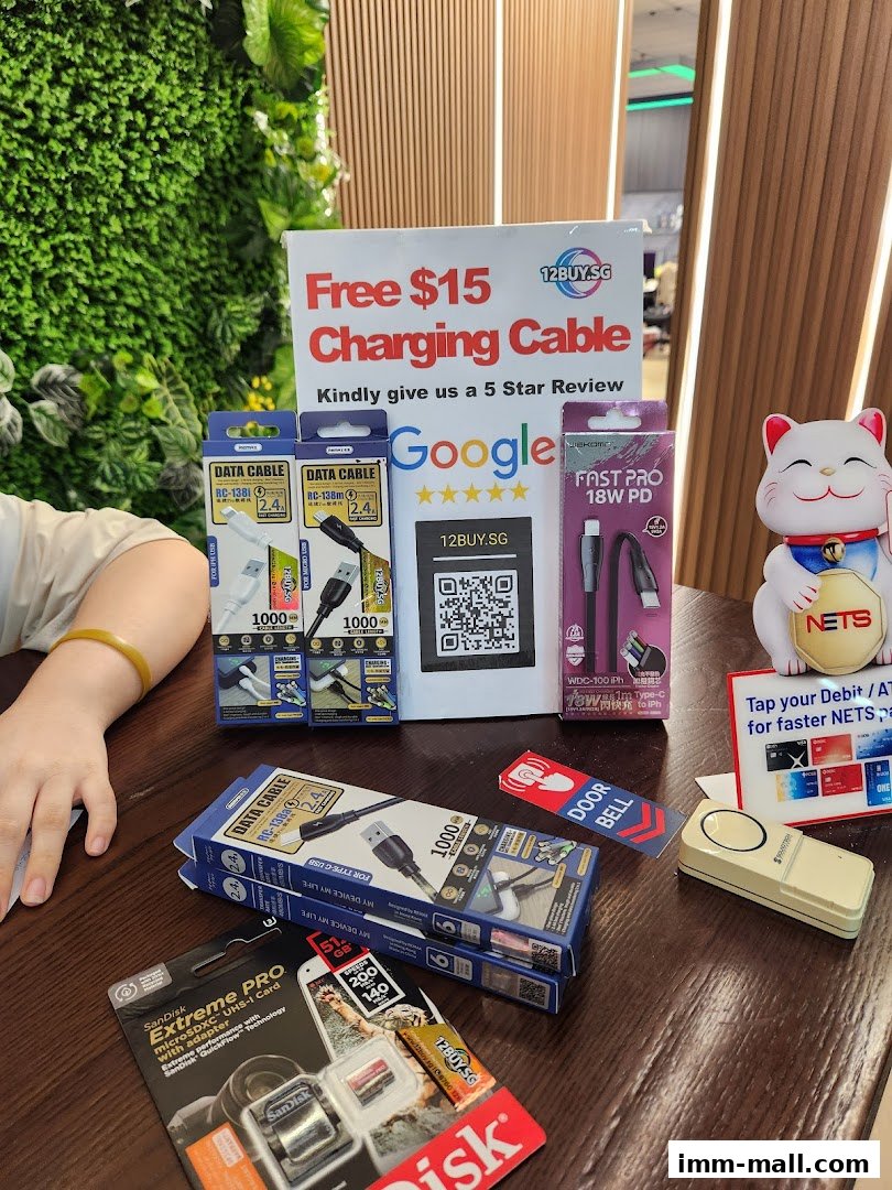 A table displaying various tech accessories including charging cables and SanDisk memory cards, with a promotional sign.