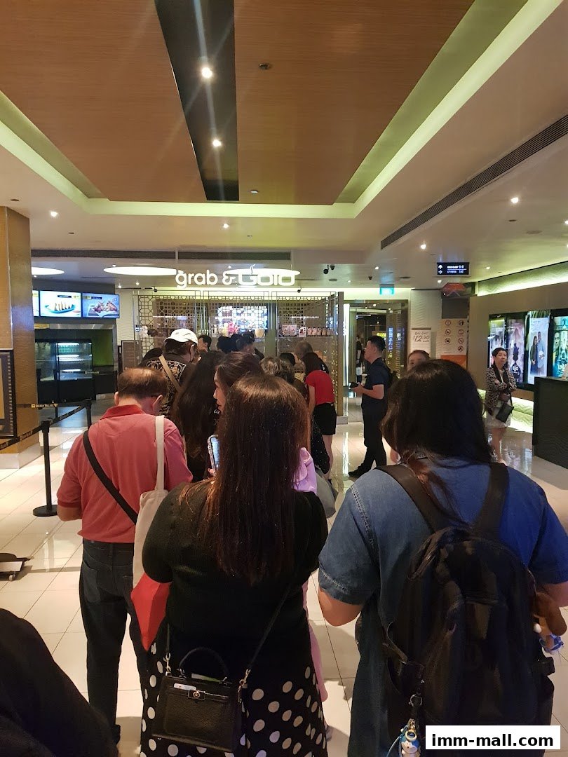 People queuing inside a mall, with a 'grab & go' food establishment visible.