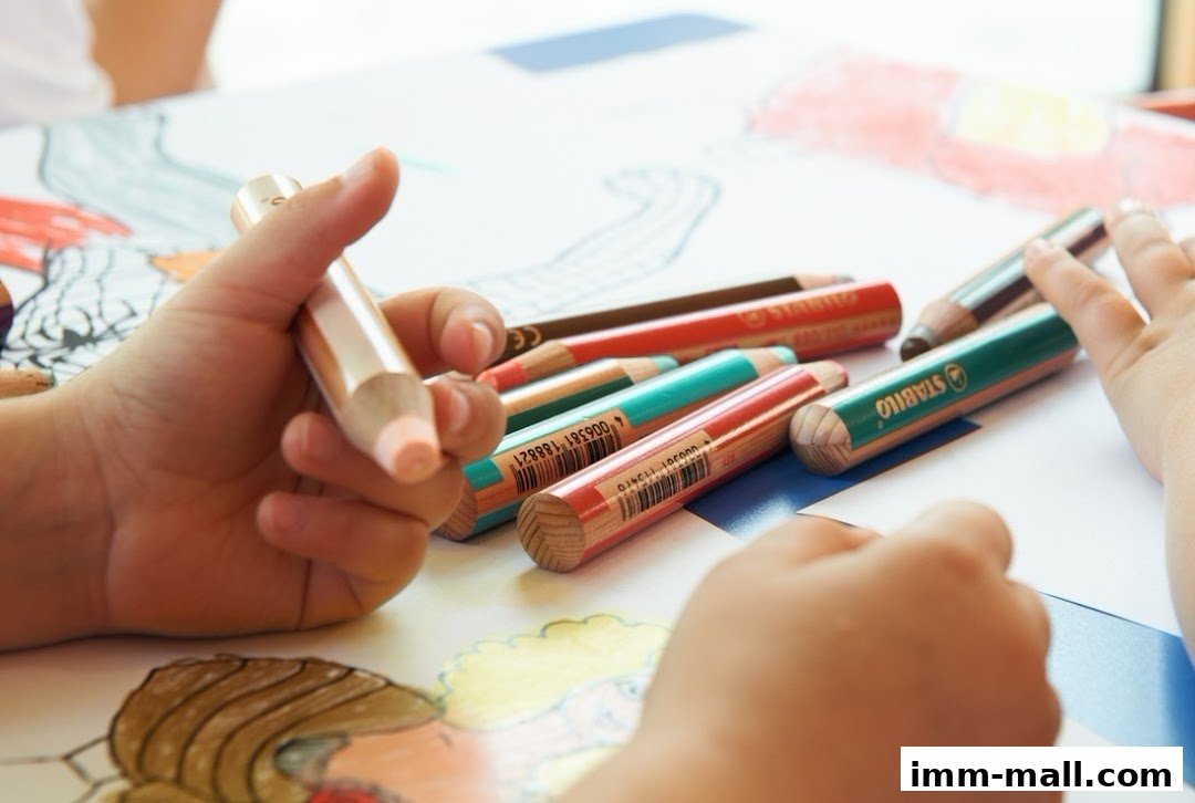 A child's hands holding and using colorful Stabilo pencils for drawing.