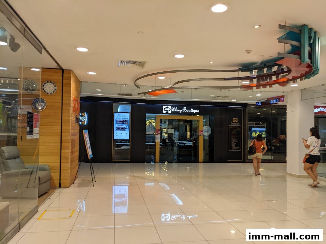 The entrance to the Sealy Sleep Boutique shop in a mall, with a display and seating area.