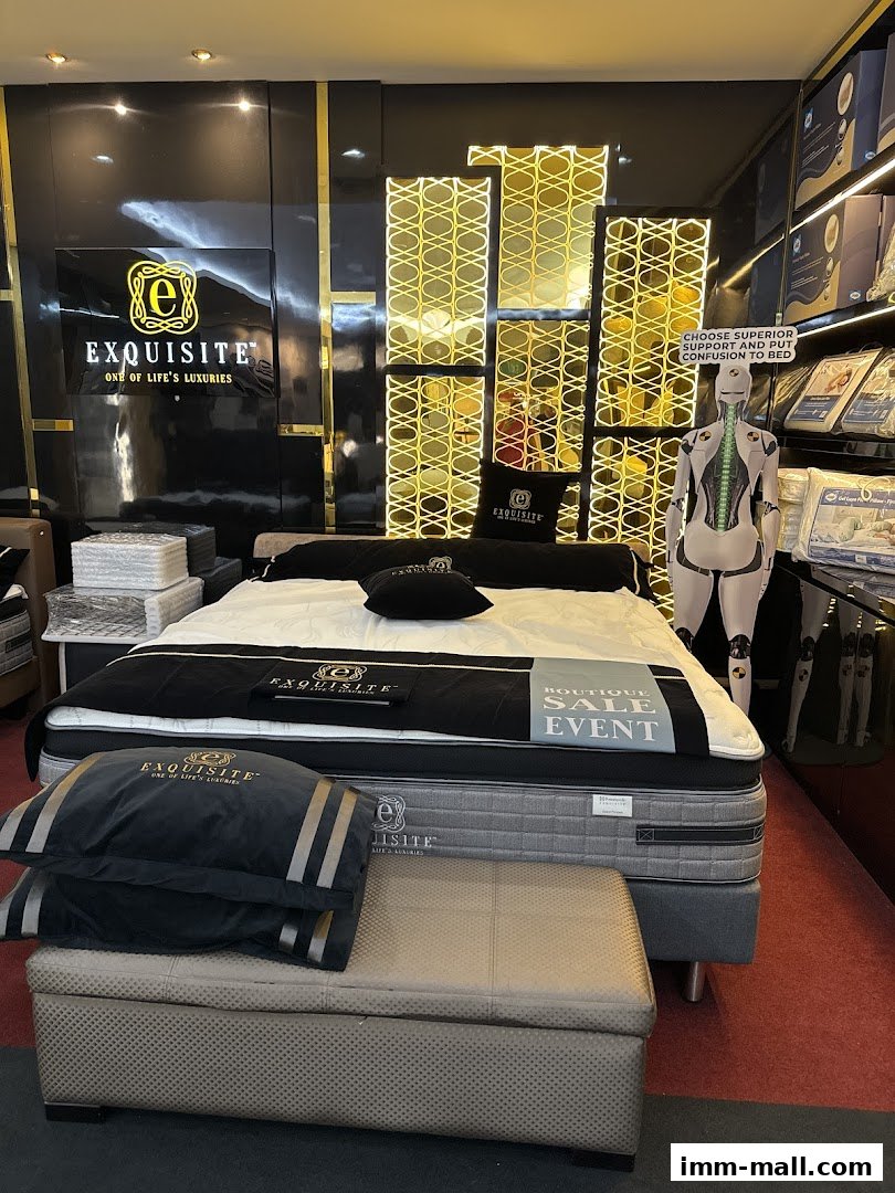 A luxurious mattress display with pillows and a mannequin in a sleep boutique.