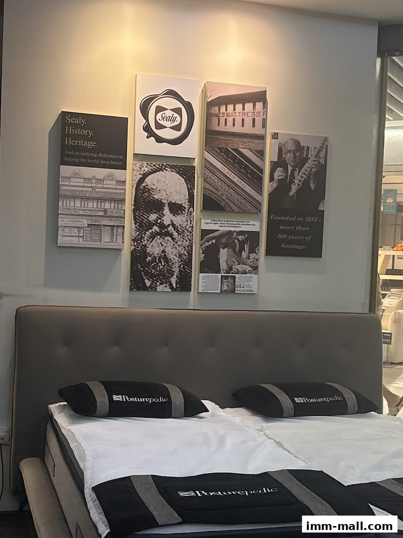 A Sealy Posturepedic bed display with historical imagery and branding.