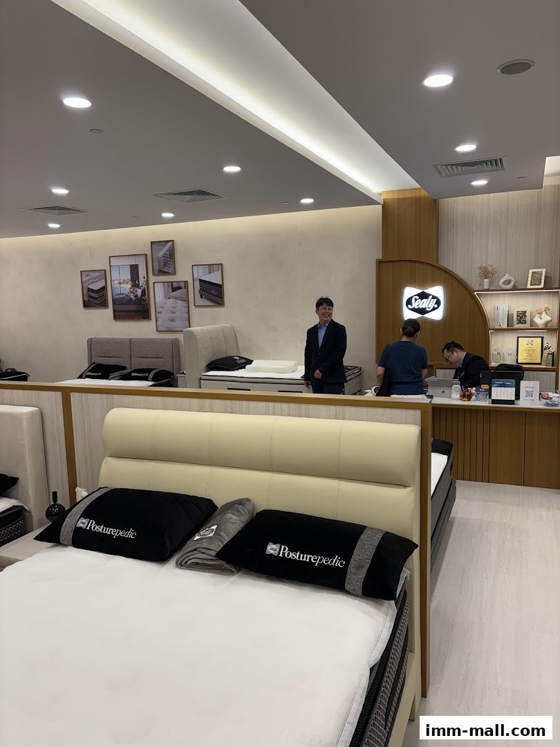 Interior of a Sealy Sleep Boutique with beds, pillows, and staff.