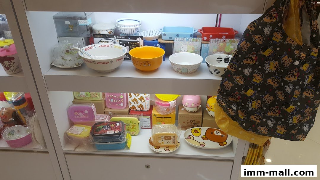 Shelves filled with cute character-themed kitchenware and accessories, including bowls, containers, and a tote bag.