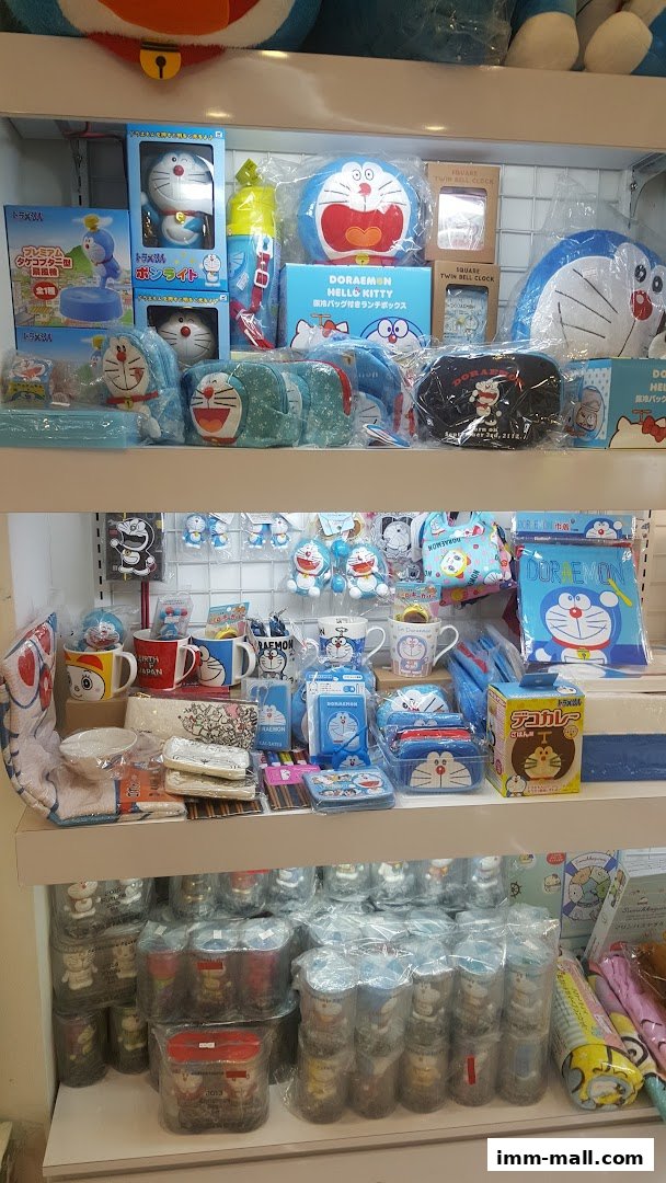 A retail display filled with various Doraemon themed merchandise, including plush toys, mugs, and stationery.