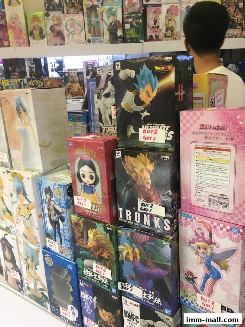 A display of anime figurines and merchandise, with a customer browsing.