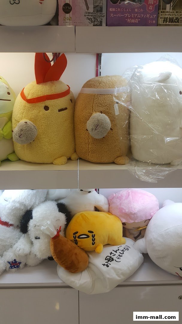 A display of various plush toys, including characters with red headbands and a crying yellow character.