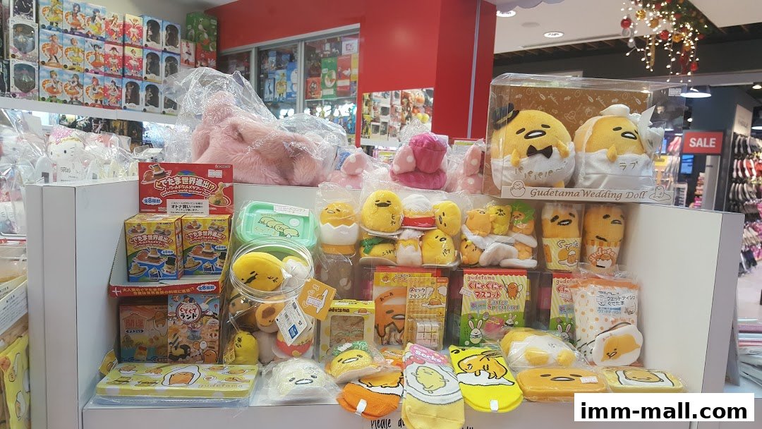 A display of Gudetama merchandise, including plush toys, socks, and stationery.