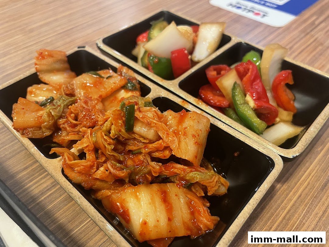 A close-up of kimchi and pickled vegetables served in black containers.