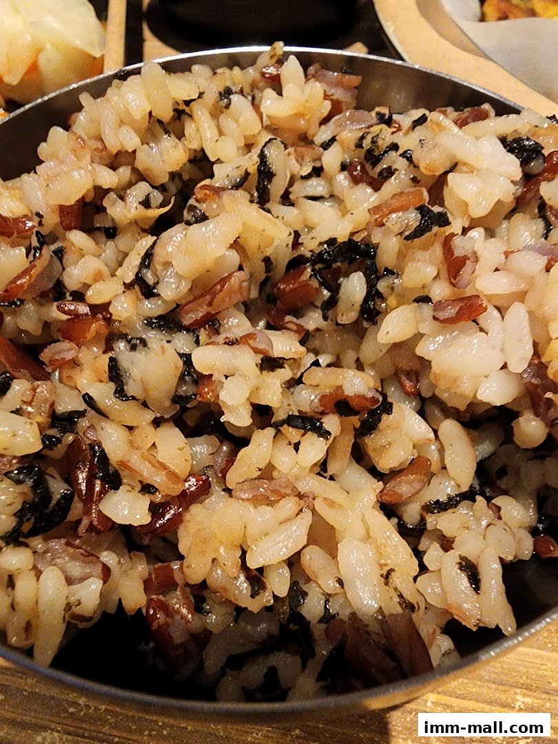 A close-up shot of a bowl filled with mixed grains and seaweed.
