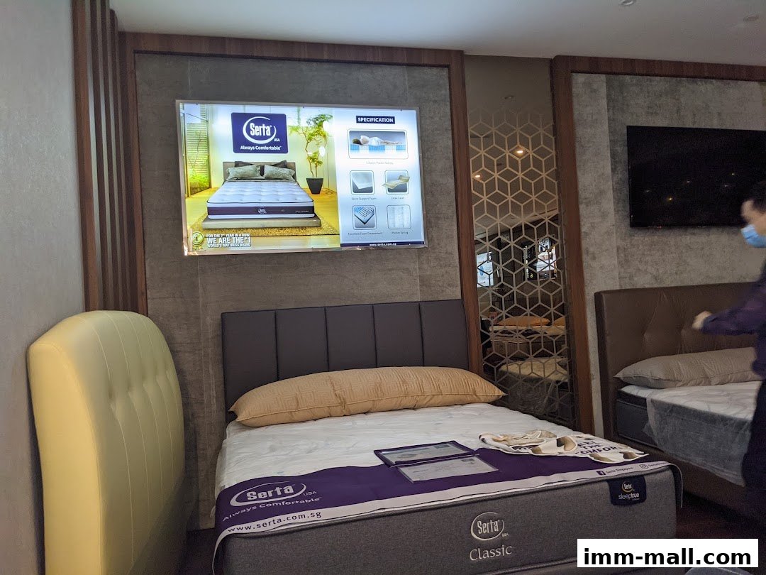 Interior of a Serta Sleep Center showing mattresses and a display screen.