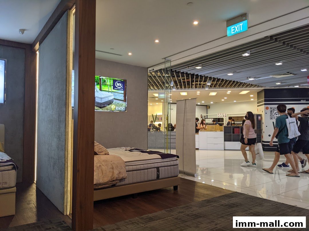 Interior view of a Serta Sleep Center with beds and customers browsing.