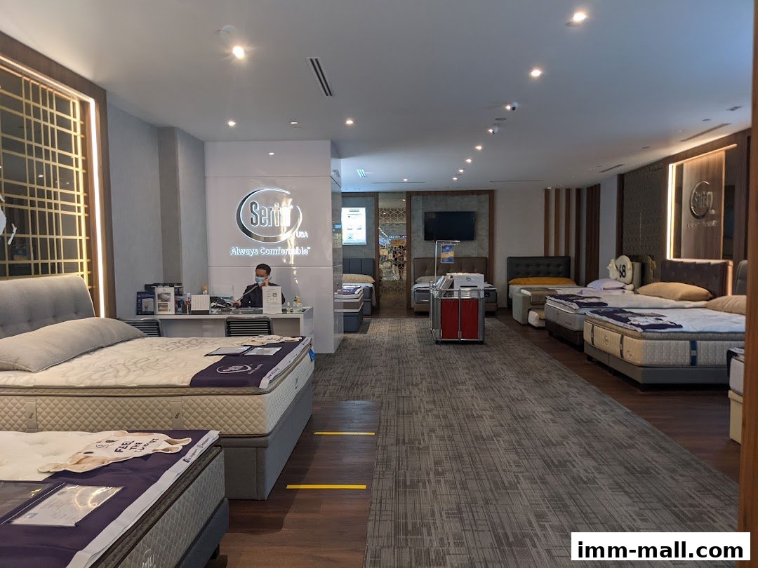 Interior of a Serta Sleep Center showcasing various mattresses and a sales associate.