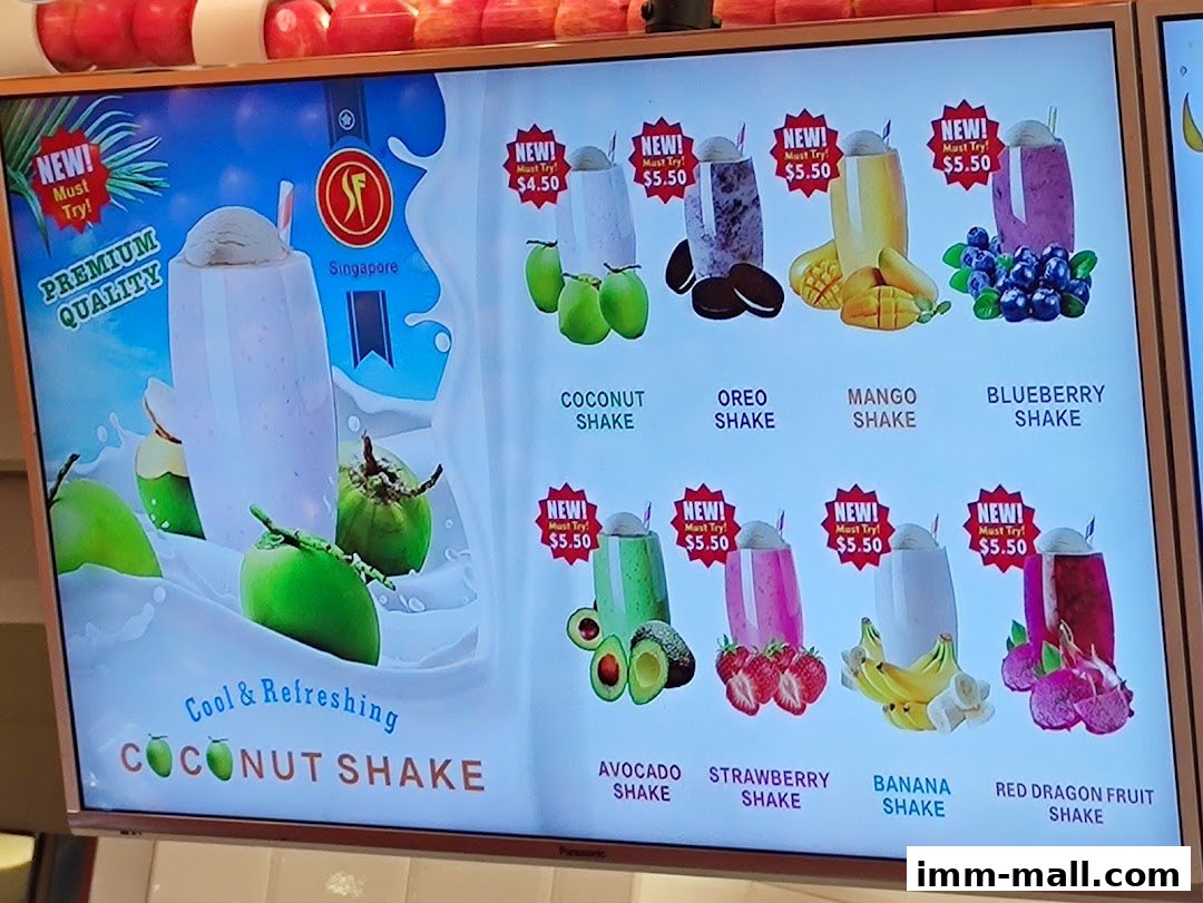 A digital menu board displaying various fruit shakes and their prices.