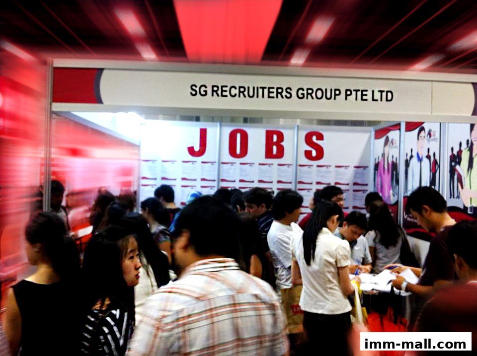 A busy recruitment event with people gathered around a booth for SG Recruiters Group Pte Ltd.