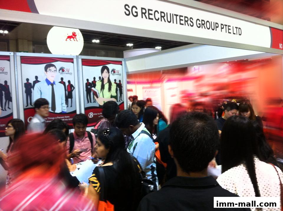 A crowd of people gathered at a recruitment event booth for SG Recruiters Group Pte Ltd.