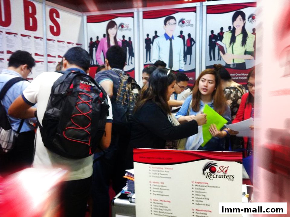 People at a job fair booth for SG Recruiters Group Pte Ltd.