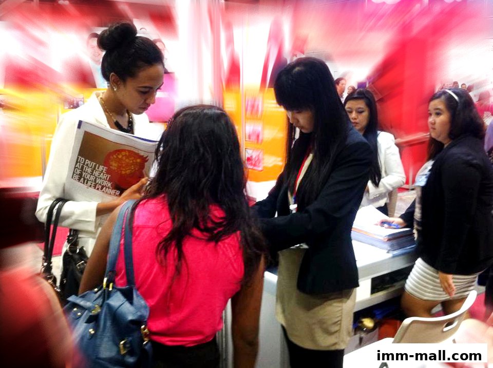 People interacting at a professional event, possibly a recruitment or career fair.