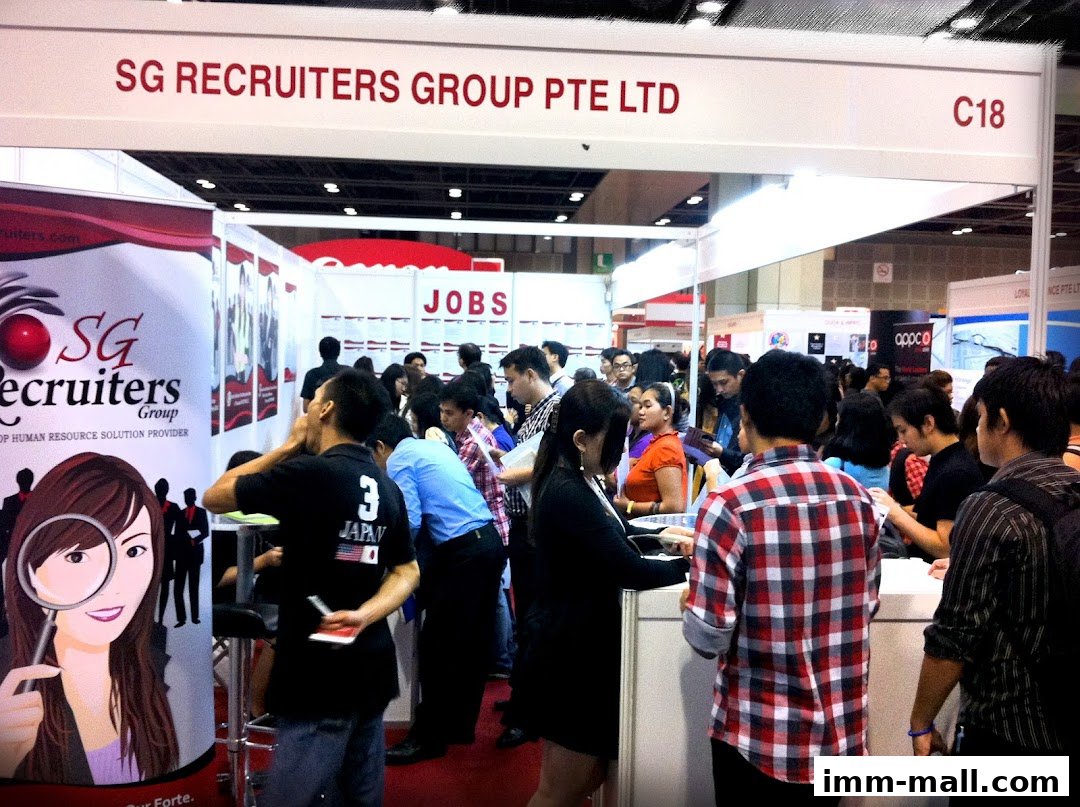 A busy recruitment fair booth with people interacting and looking for jobs.