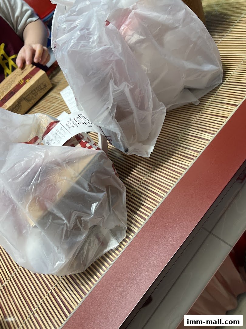 Two plastic bags filled with food from Shihlin Taiwan Street Snacks on a bamboo mat.