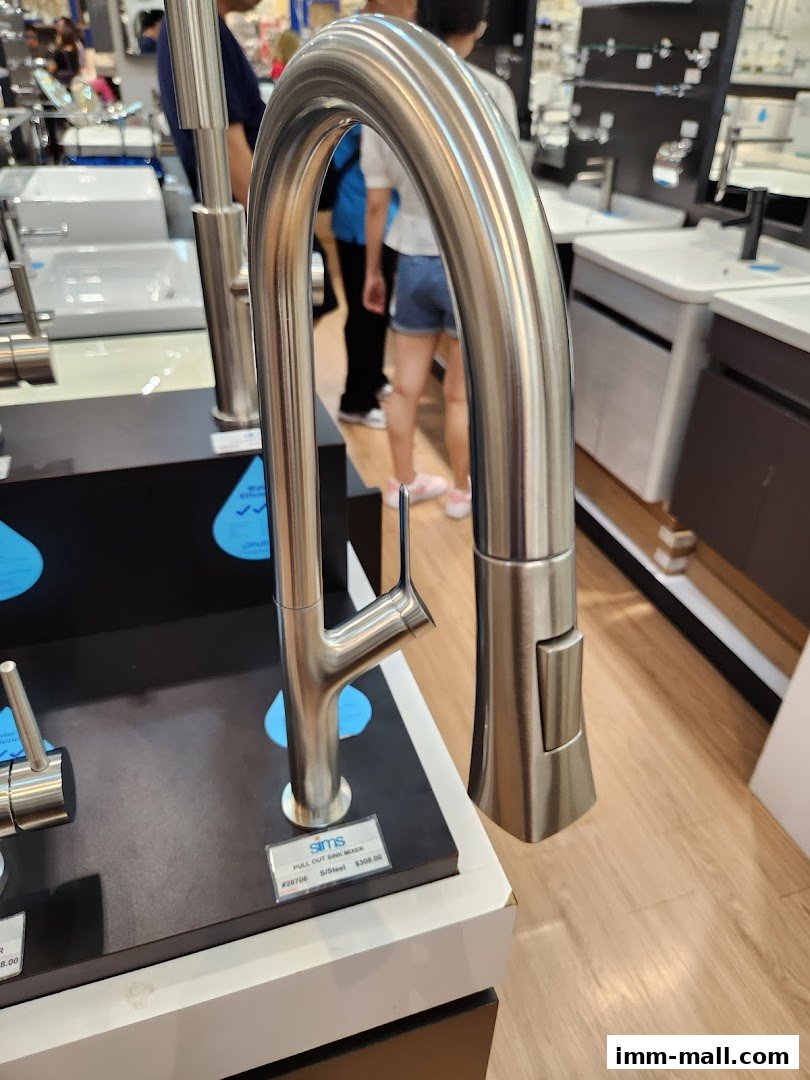 A close-up of a modern stainless steel kitchen faucet on display in a store.
