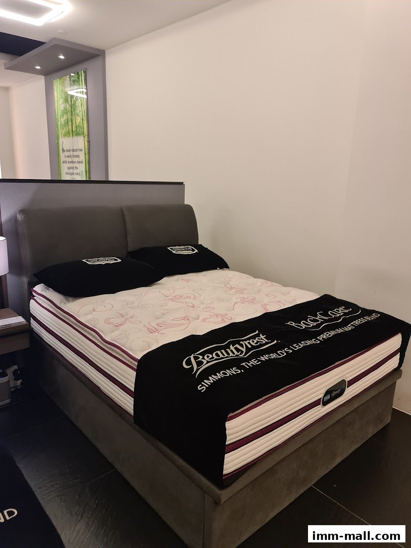A Simmons Beautyrest BackCare mattress displayed on a bed frame in a showroom.