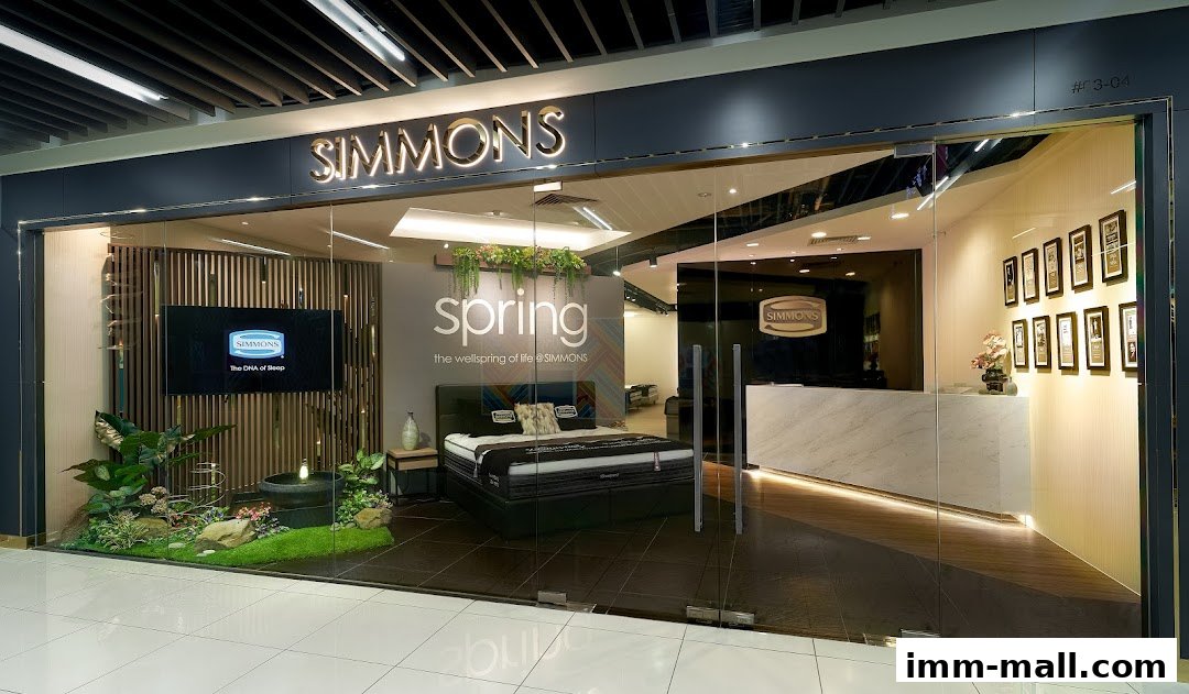 The Simmons Gallery shop front features a display bed, a reception desk, and decorative elements.