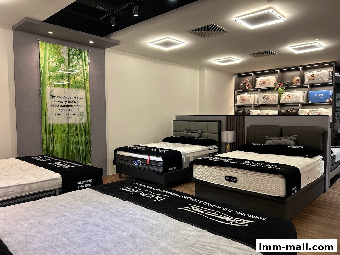 Interior view of a Simmons Gallery showroom with multiple beds and displayed mattress products.