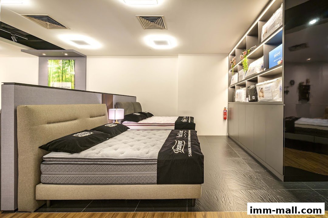 Interior view of a Simmons Gallery mattress store with beds and displayed products.