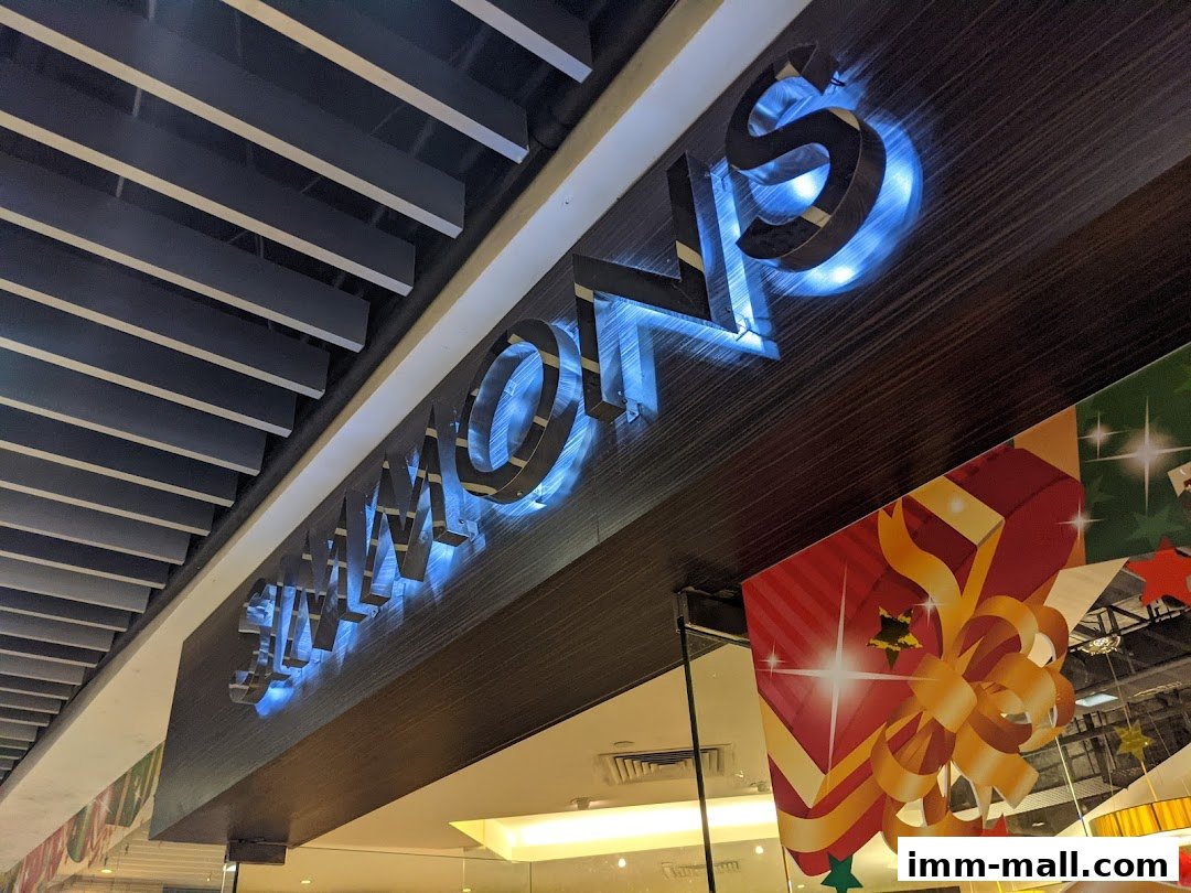 The Simmons Gallery shop sign with illuminated letters and festive decorations.