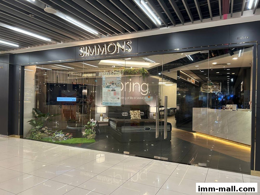 The Simmons Gallery shop front displays mattresses and bedroom furniture through its glass facade.