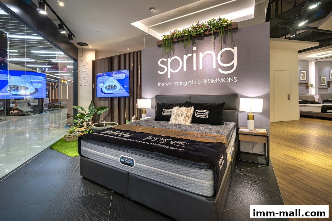A Simmons mattress display with a bed, pillows, and decorative elements in a modern showroom.