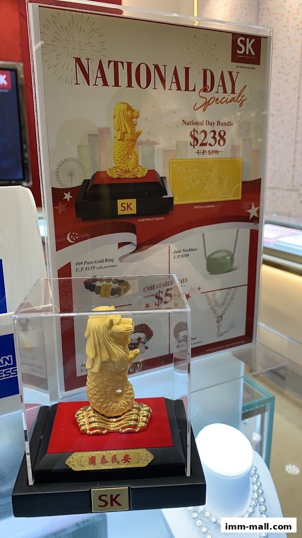 SK Jewellery National Day specials featuring gold figurines, rings, necklaces, and gold bars.