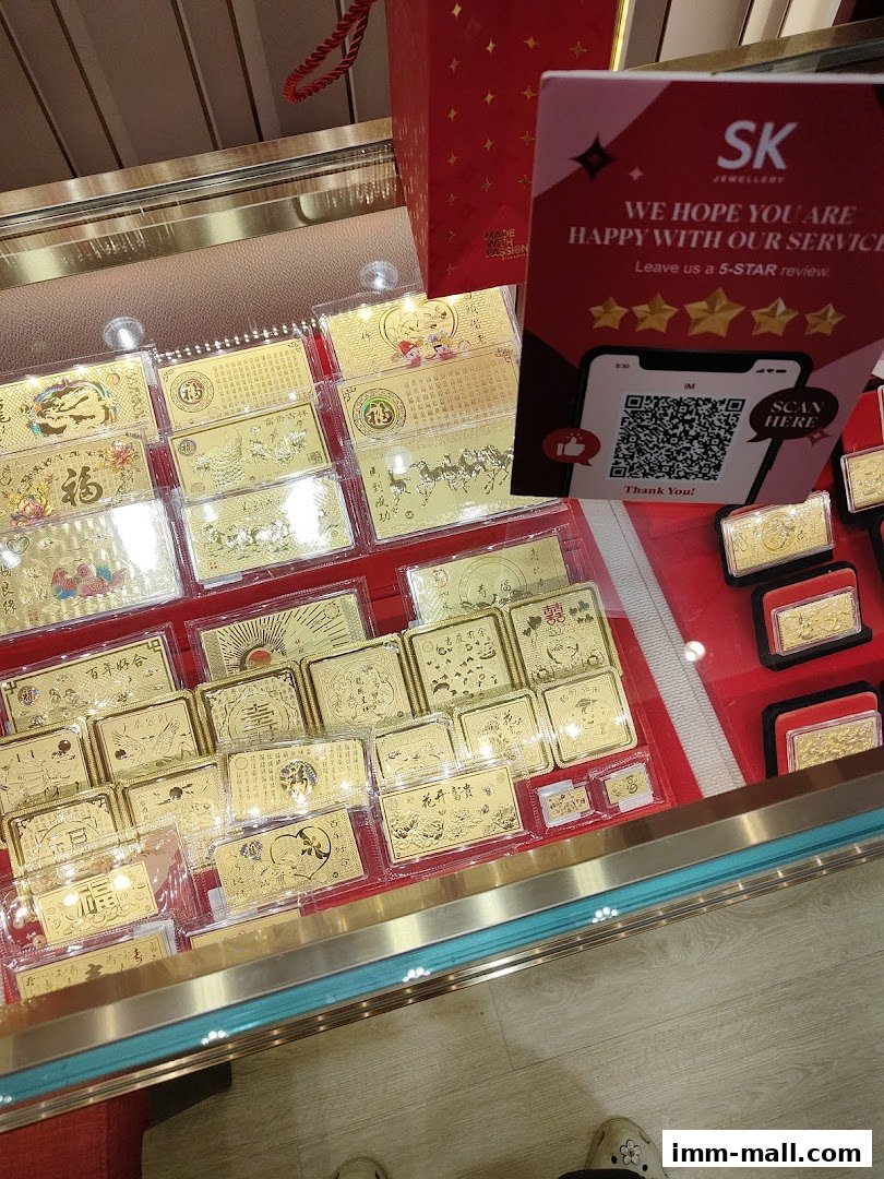 Display case filled with gold bars and plaques featuring auspicious Chinese motifs.