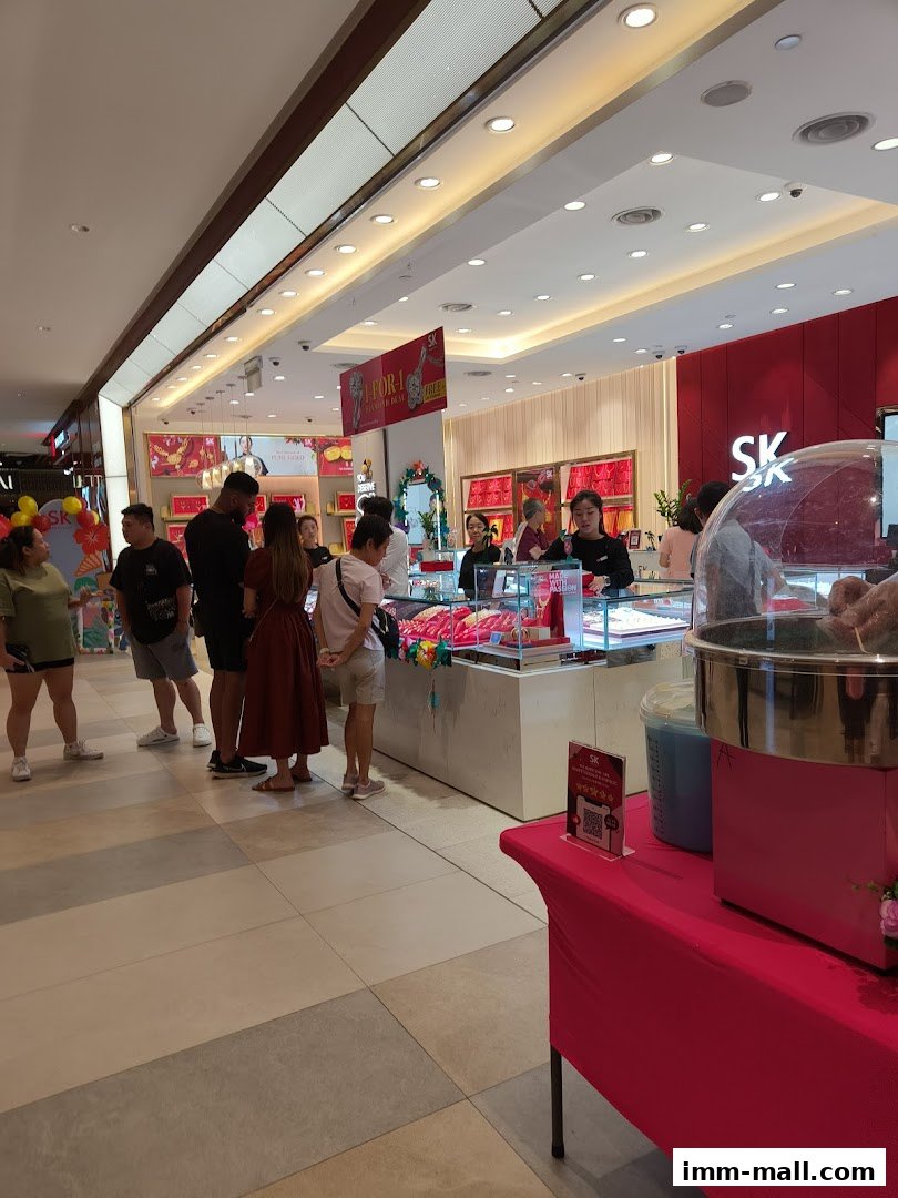 Customers browse jewelry at SK Jewellery, with a promotional sign and a cotton candy machine visible.