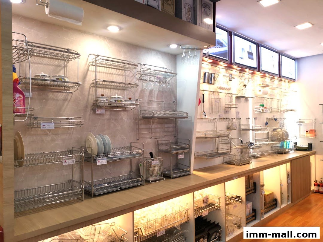 A well-lit shop interior showcasing a wide variety of stainless steel kitchen racks and organizers.