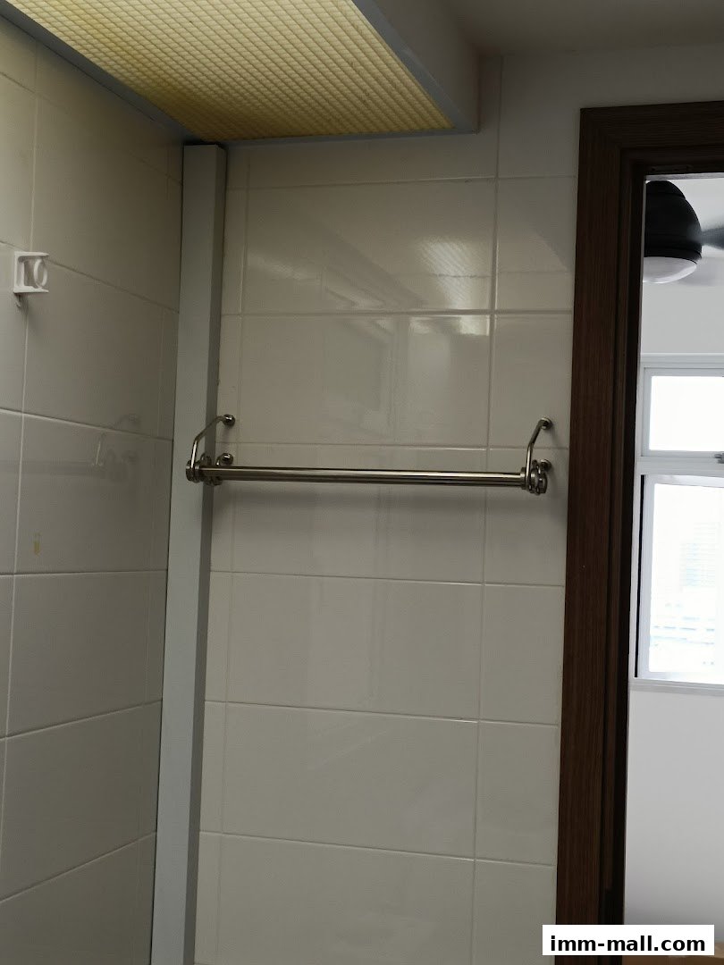 A towel rack mounted on a tiled wall next to a doorway.
