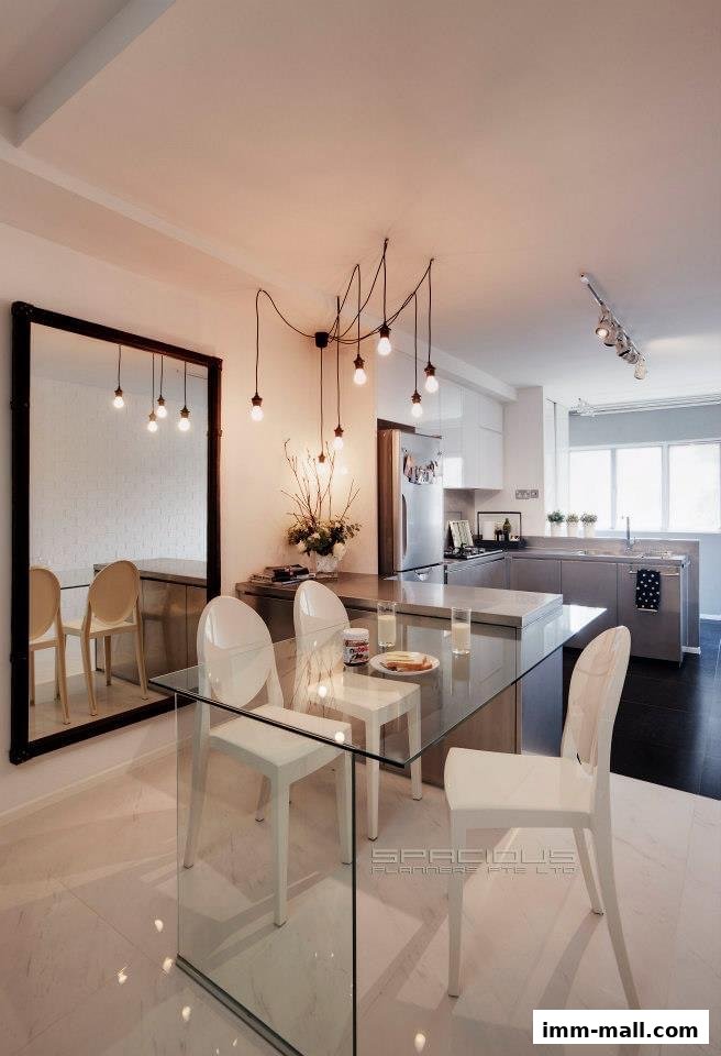 A modern dining area and kitchen with a glass table and chairs, and a large mirror.