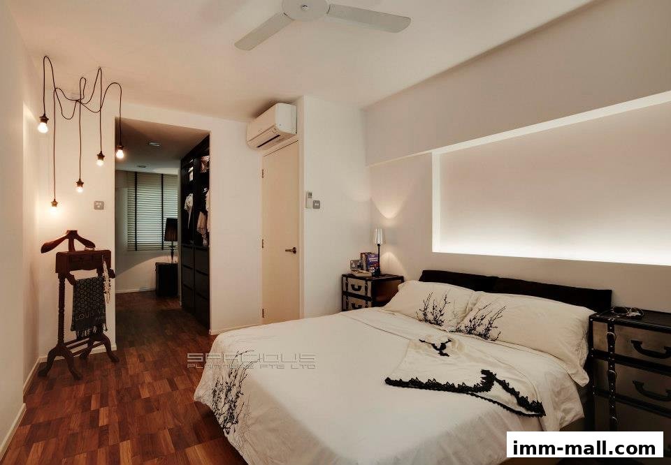 A modern bedroom with a bed, closet, and unique lighting fixtures.