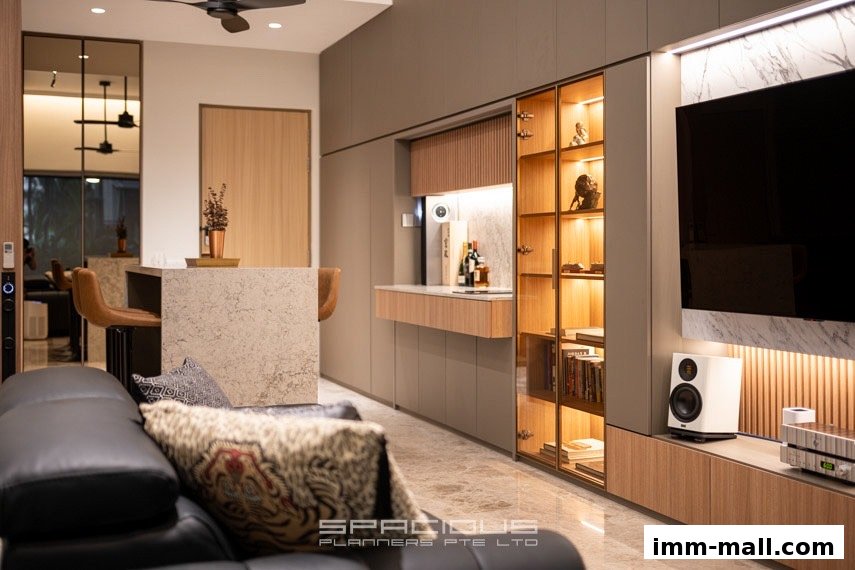 A modern living room with a sleek kitchen island, built-in cabinets, and a large television.