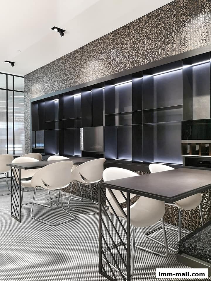 Modern interior with tables and chairs, featuring a mosaic wall and sleek black accents.