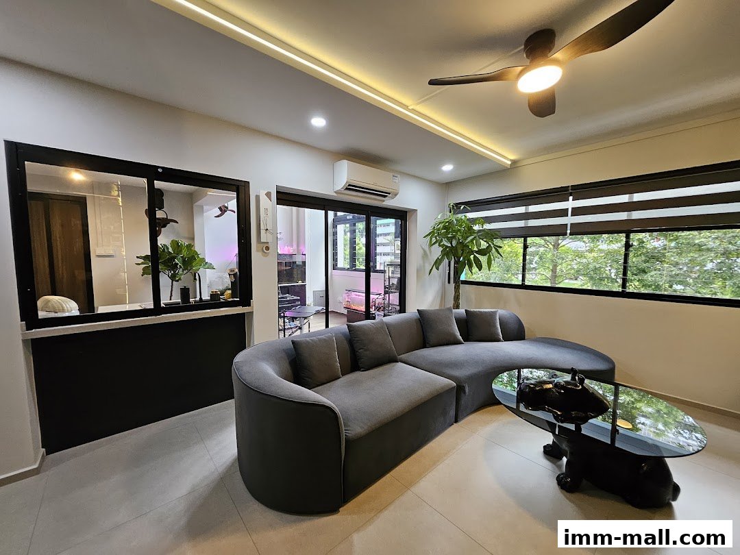 A modern living room with a curved grey sofa, unique coffee table, and large windows.