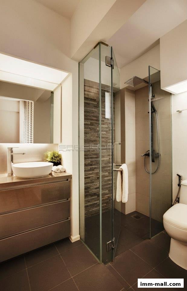 A modern bathroom with a glass-enclosed shower, vanity, and toilet.