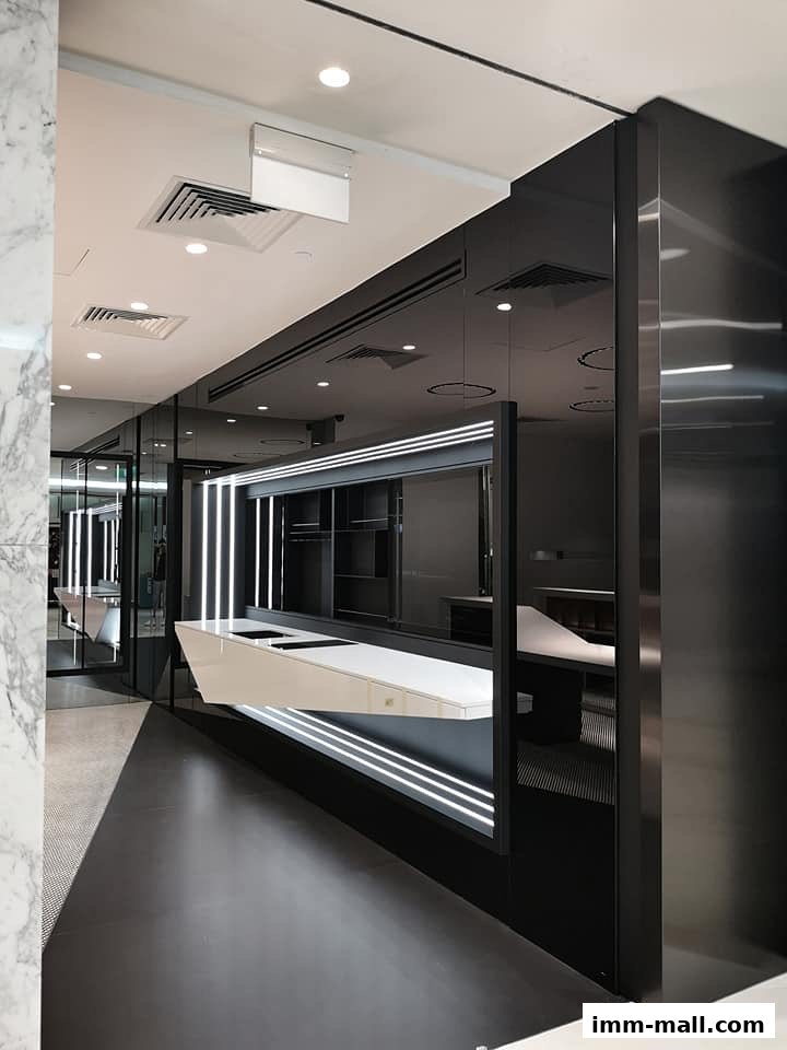 Modern retail interior with sleek black and white design, featuring illuminated displays and marble accents.